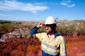 Minerador de capacete observando o horizonte em um campo aberto.