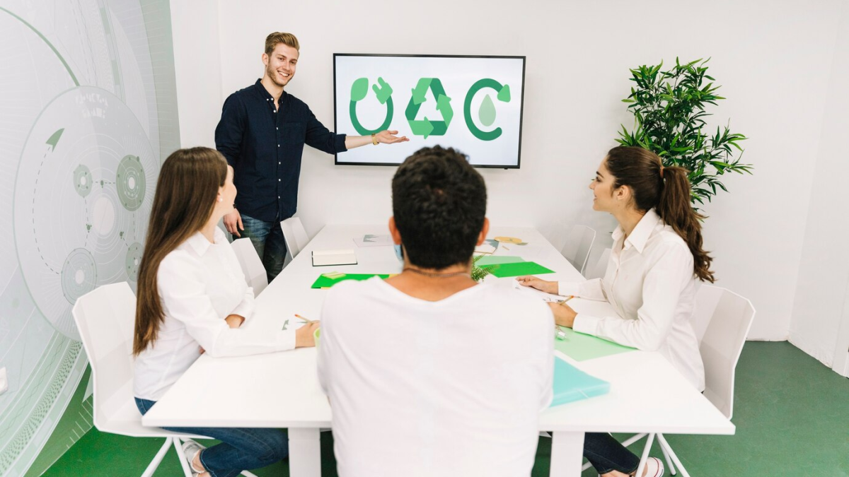 Apresentação sobre reciclagem e com quatro pessoas em uma sala de reunião.